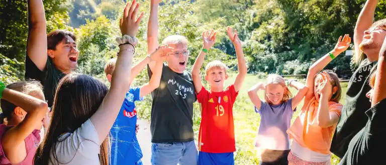 Kinder und Betreuende jubeln gemeinsam im Ferienwaldheim.