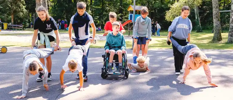 Kinder mit und ohne Behinderung spielen gemeinsam auf dem Gelände des Ferienwaldheims.