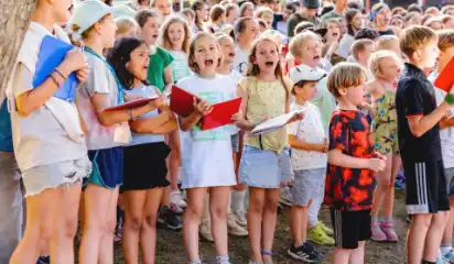 Kindergruppe singt gemeinsam mit einem Liedheft.