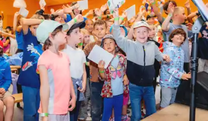 Kinder feiern verkleidet bei einem Programm im Ferienwaldheim.