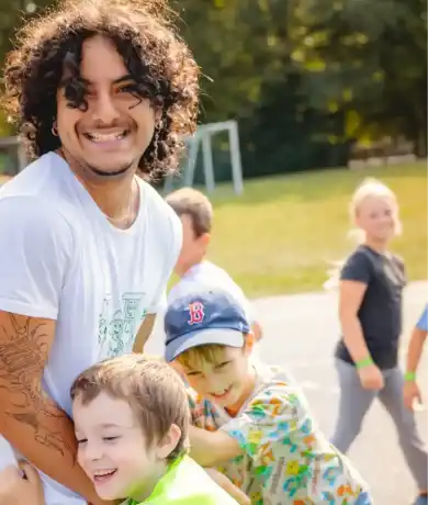 Betreuer begleitet Kinder auf dem Waldheimgelände.