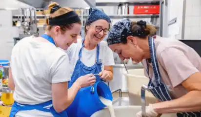 Küchenteam arbeitet gemeinsam an einer großen Schüssel.