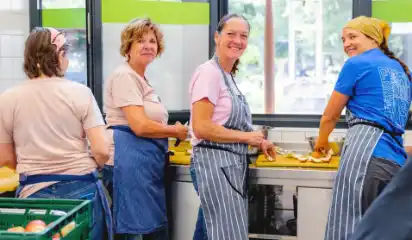 Küchenteam richtet Essen für die Ausgabe an.