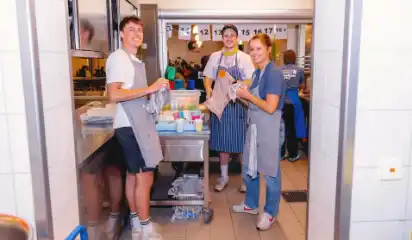 Küchenteam transportiert Essen auf einem Wagen.